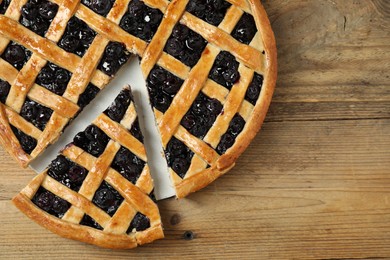 Photo of Tasty homemade pie with blueberries on wooden table, top view. Space for text