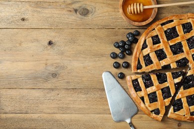 Photo of Tasty homemade pie with blueberries served on wooden table, flat lay. Space for text