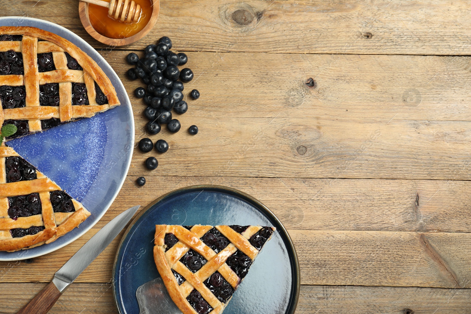 Photo of Tasty homemade pie with blueberries served on wooden table, flat lay. Space for text