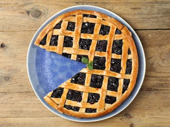 Photo of Tasty homemade pie with blueberries on wooden table, top view