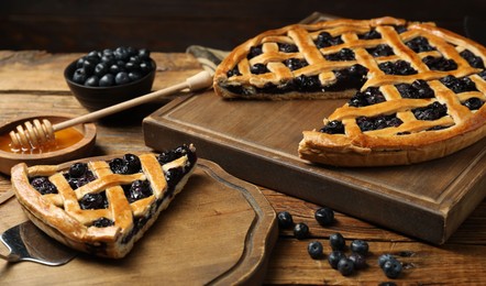 Photo of Tasty homemade pie with blueberries served on wooden table