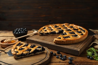 Tasty homemade pie with blueberries served on wooden table