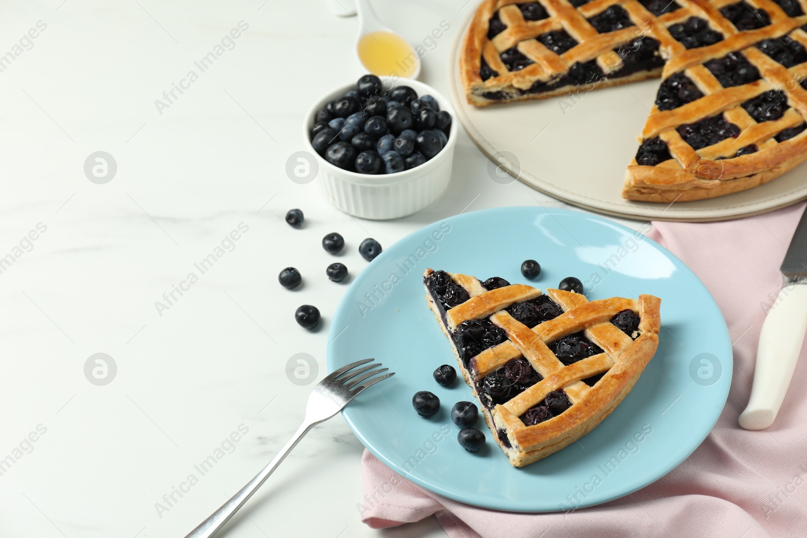 Photo of Tasty homemade pie with blueberries served on white marble table