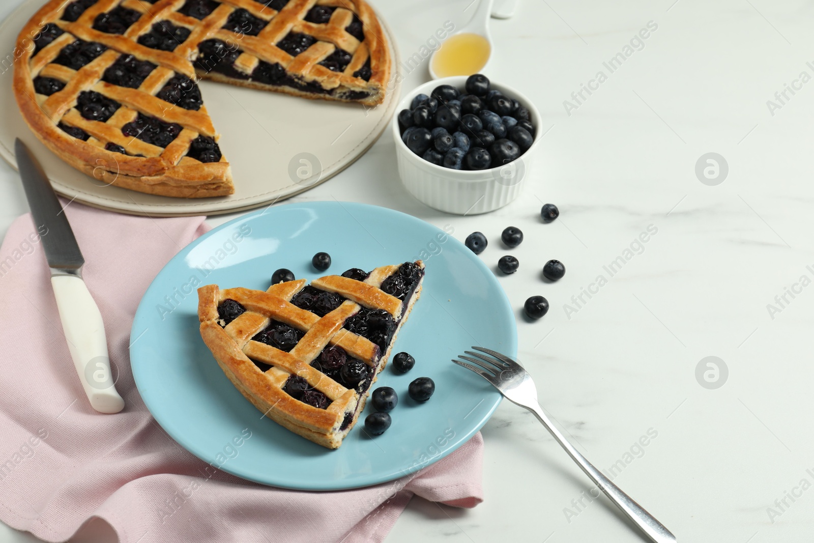 Photo of Tasty homemade pie with blueberries served on white marble table