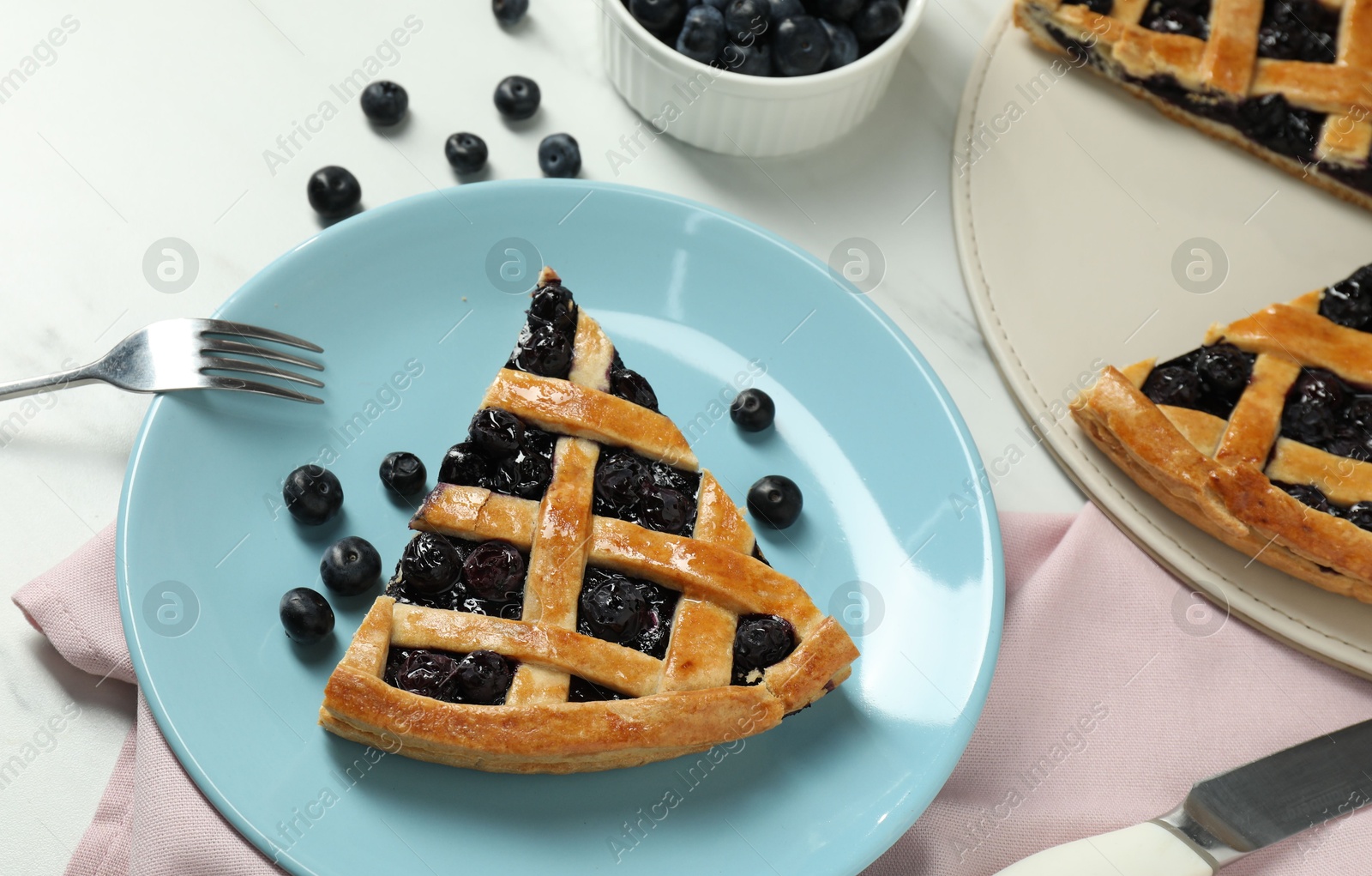 Photo of Tasty homemade pie with blueberries served on white marble table