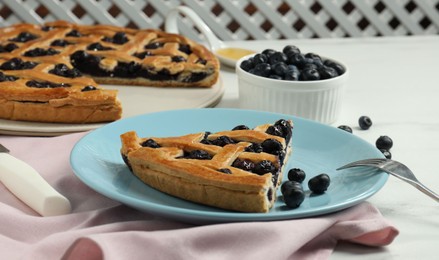 Photo of Piece of tasty homemade pie with blueberries served on white table