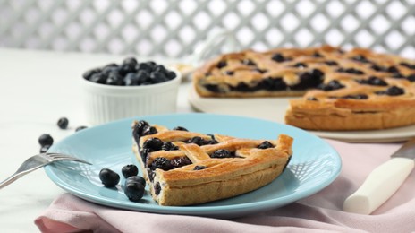 Photo of Piece of tasty homemade pie with blueberries served on white table, closeup