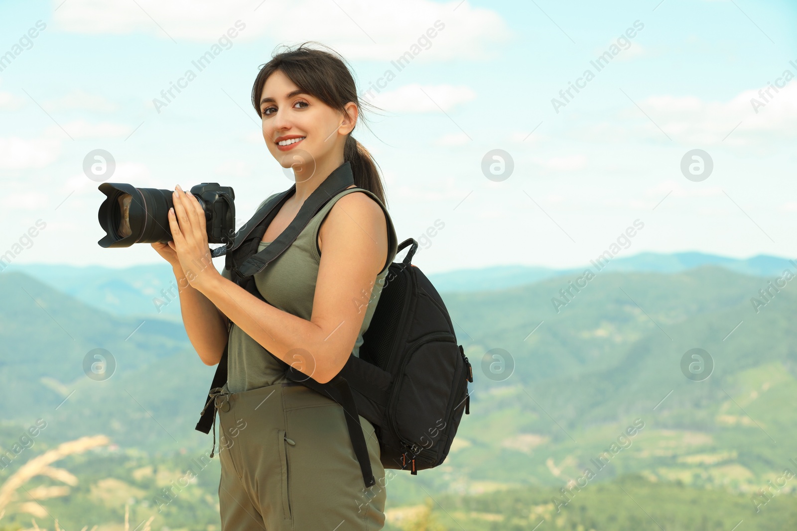 Photo of Photographer with backpack and camera in mountains, space for text