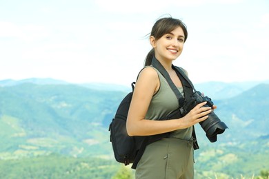 Photo of Photographer with backpack and camera in mountains