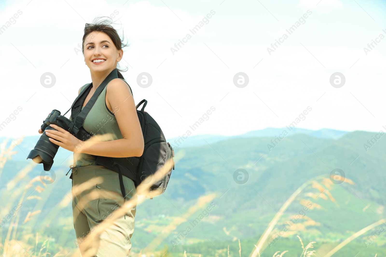 Photo of Photographer with backpack and camera in mountains, space for text