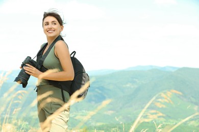 Photo of Photographer with backpack and camera in mountains, space for text