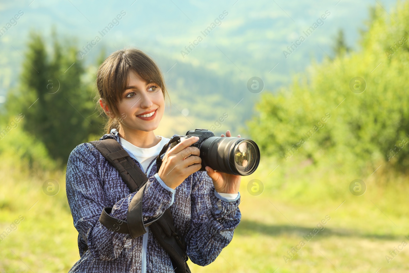 Photo of Photographer with backpack and camera on sunny day. Space for text