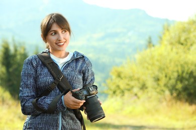 Photographer with backpack and camera in beautiful mountains. Space for text