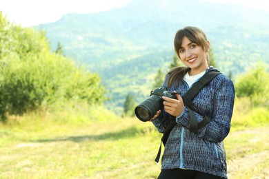 Photographer with backpack and camera in beautiful mountains. Space for text