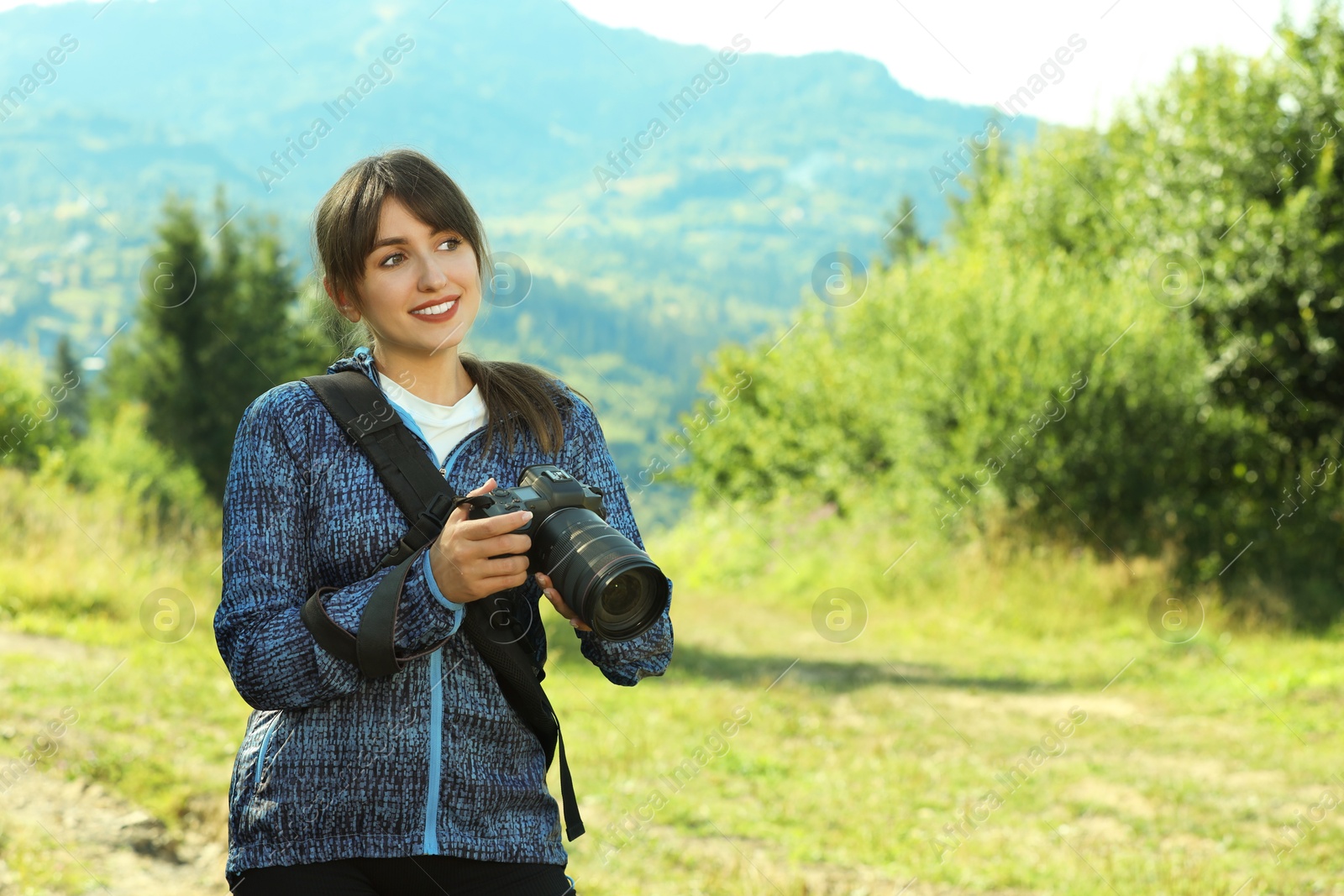 Photo of Photographer with backpack and camera in beautiful mountains. Space for text