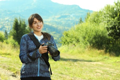 Photographer with backpack and camera in beautiful mountains. Space for text