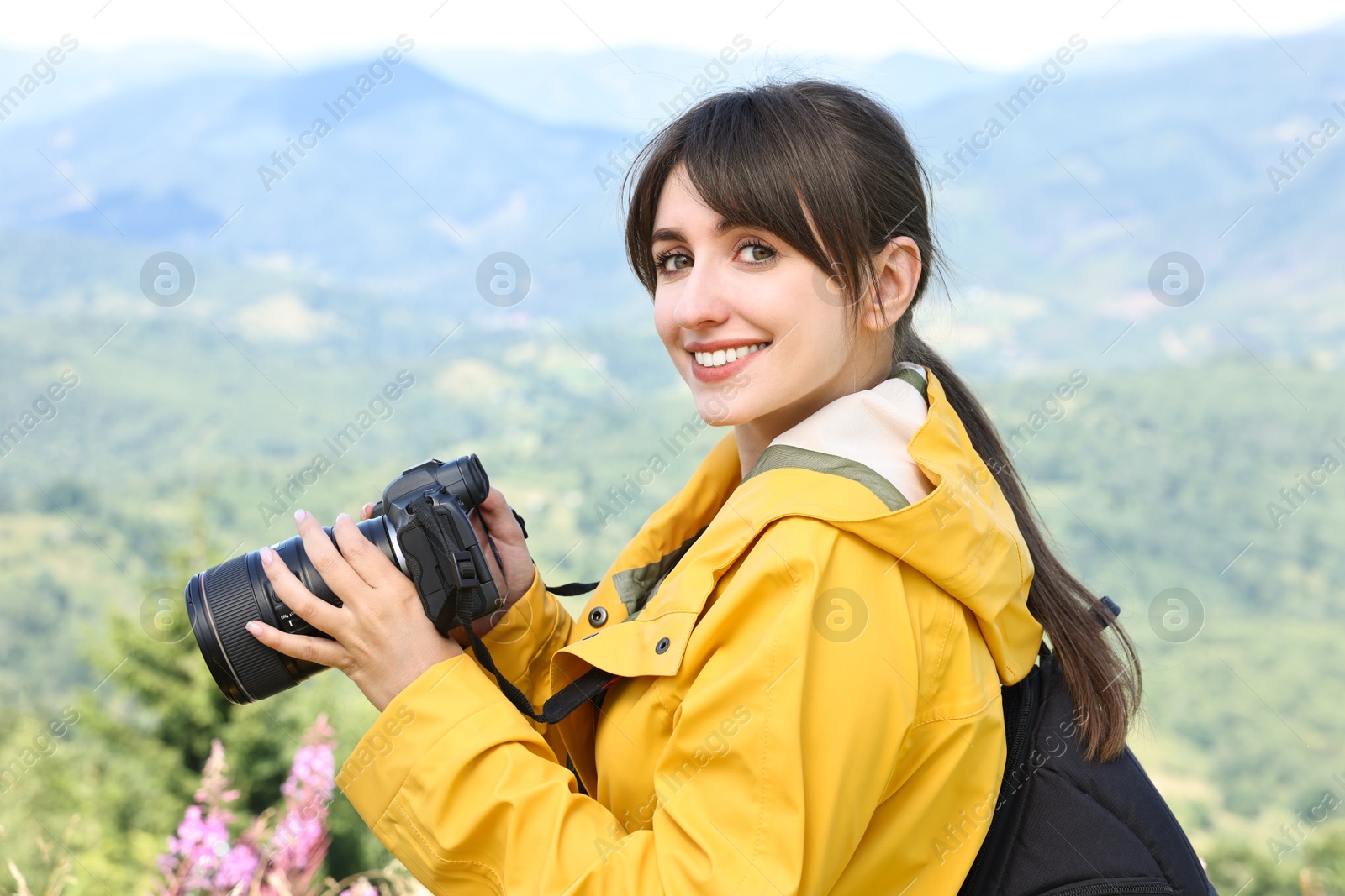 Photo of Photographer with backpack and camera in beautiful mountains