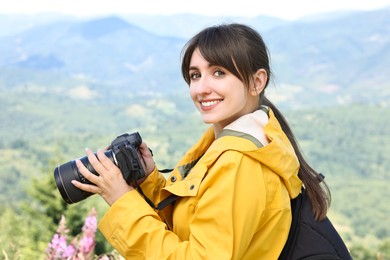 Photo of Photographer with backpack and camera in beautiful mountains