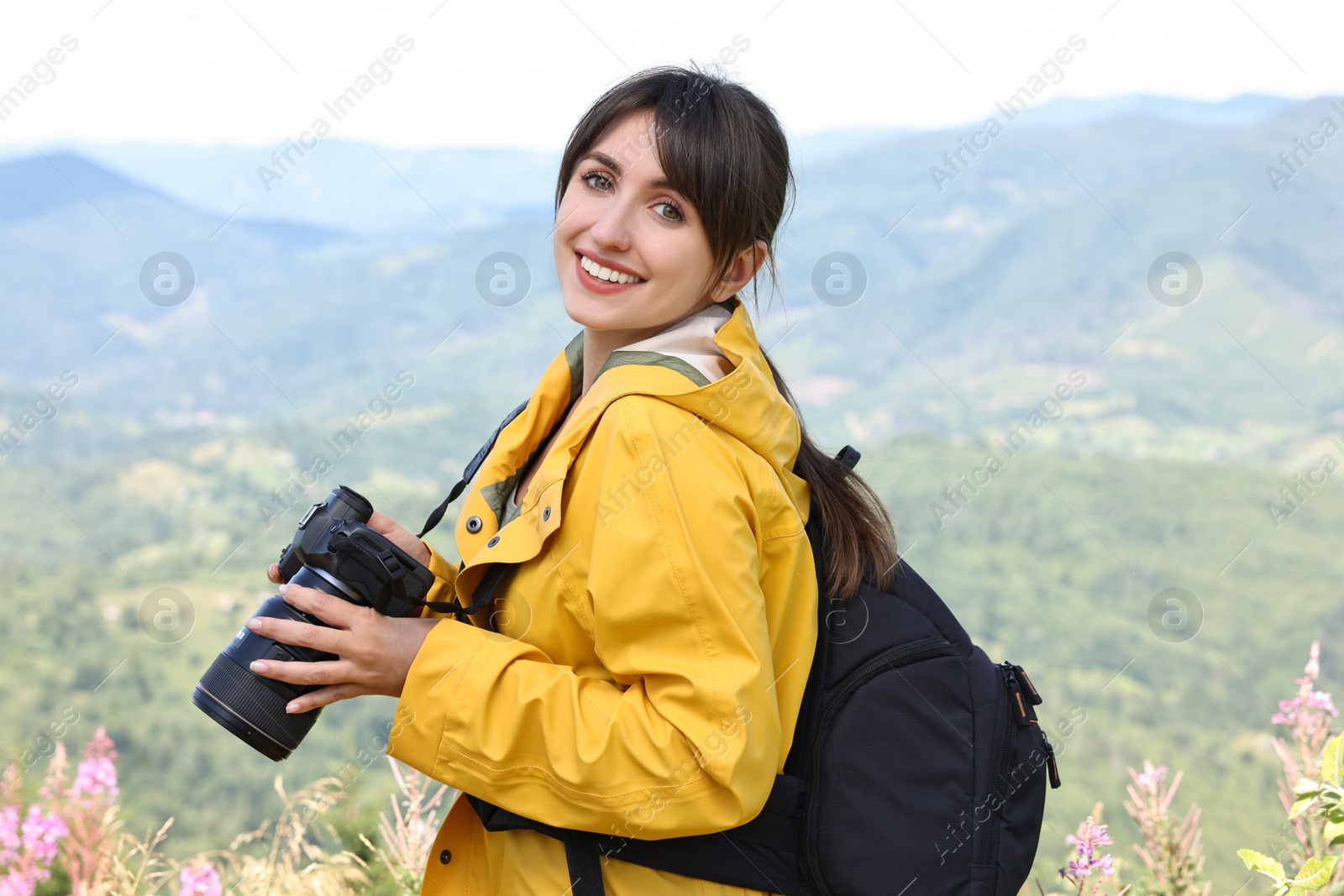 Photo of Photographer with backpack and camera in beautiful mountains