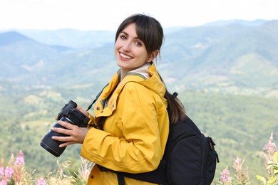 Photo of Photographer with backpack and camera in beautiful mountains