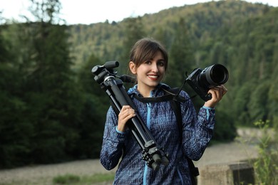 Photographer with backpack, camera and other professional equipment outdoors