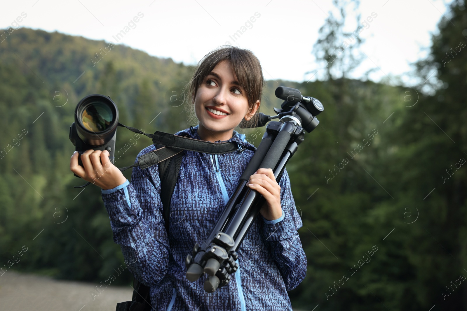 Photo of Photographer with backpack, camera and other professional equipment outdoors