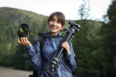 Photographer with backpack, camera and other professional equipment outdoors