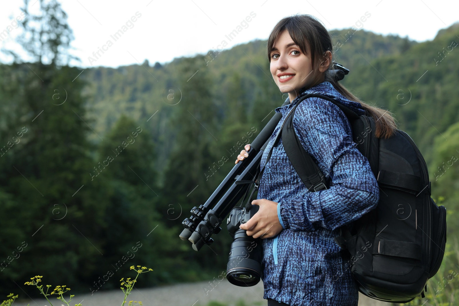 Photo of Photographer with backpack, camera and other professional equipment outdoors. Space for text