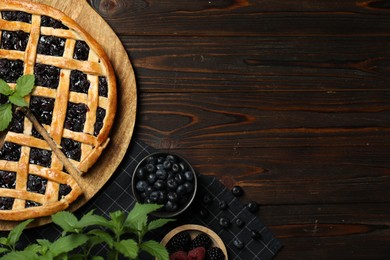 Photo of Tasty homemade pie with blueberries, fresh berries and mint on wooden table, flat lay. Space for text