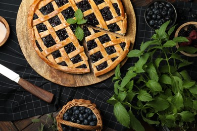 Photo of Tasty homemade pie with blueberries, fresh berries, mint and knife on wooden table, flat lay