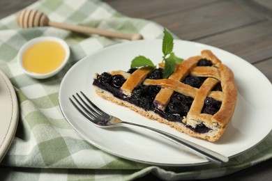 Photo of Piece of tasty homemade pie with blueberries served on table, closeup