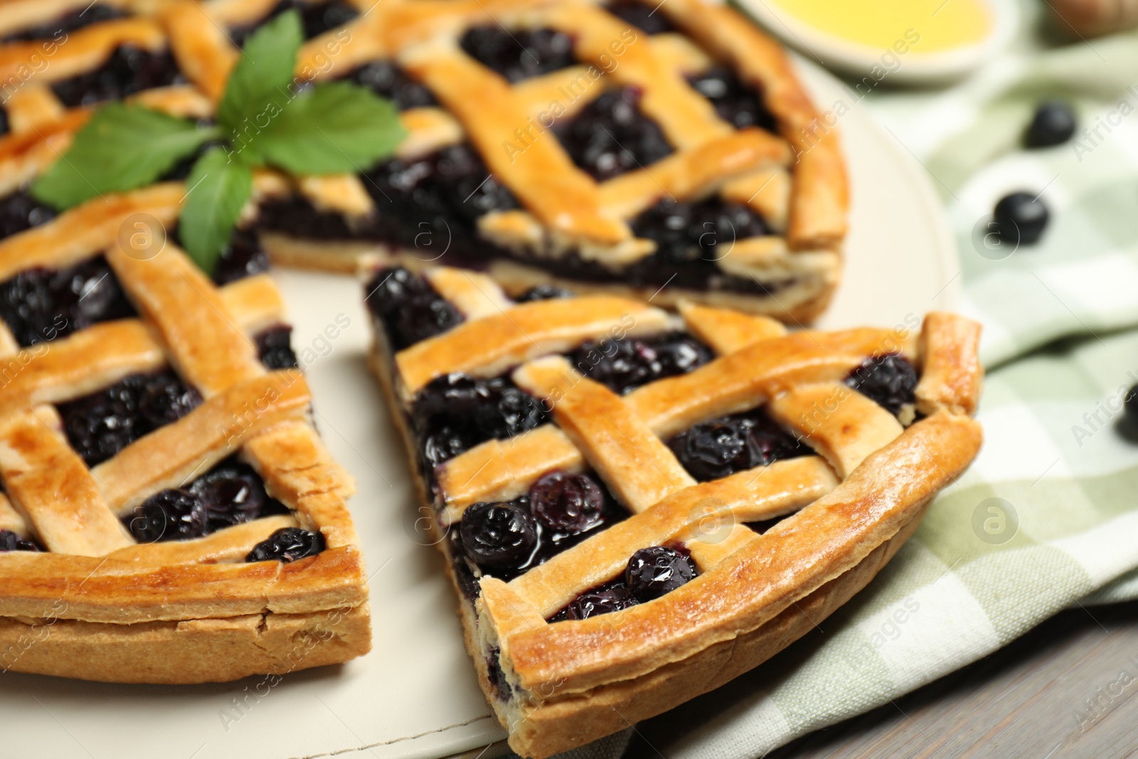 Photo of Tasty homemade pie with blueberries and mint on table, closeup