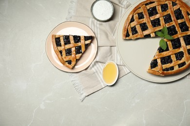 Photo of Tasty homemade pie with blueberries, honey and powdered sugar on gray textured table, flat lay. Space for text