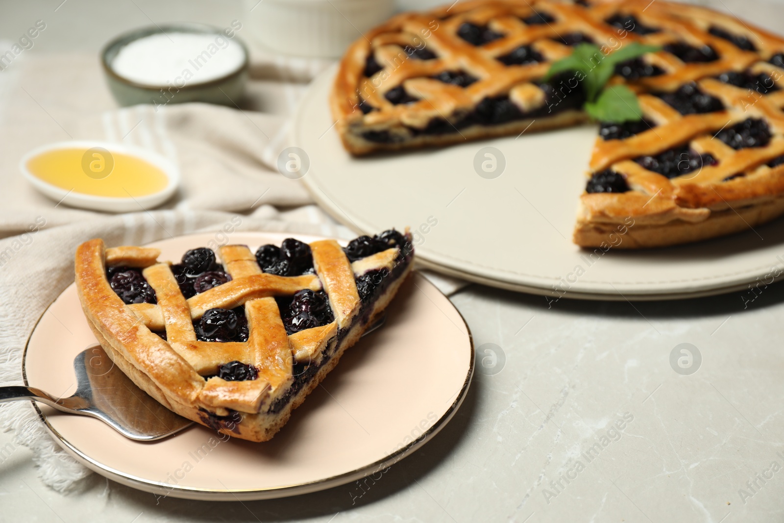 Photo of Tasty homemade pie with blueberries and cake server on gray textured table, closeup