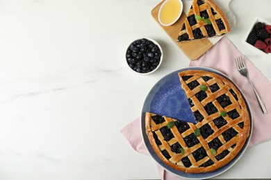 Photo of Tasty homemade pie with blueberries, fresh berries, honey and fork on white marble table, flat lay. Space for text