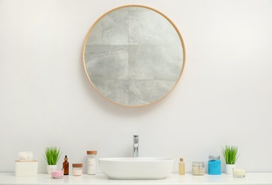 Photo of Countertop with sink, houseplants and mirror in bathroom