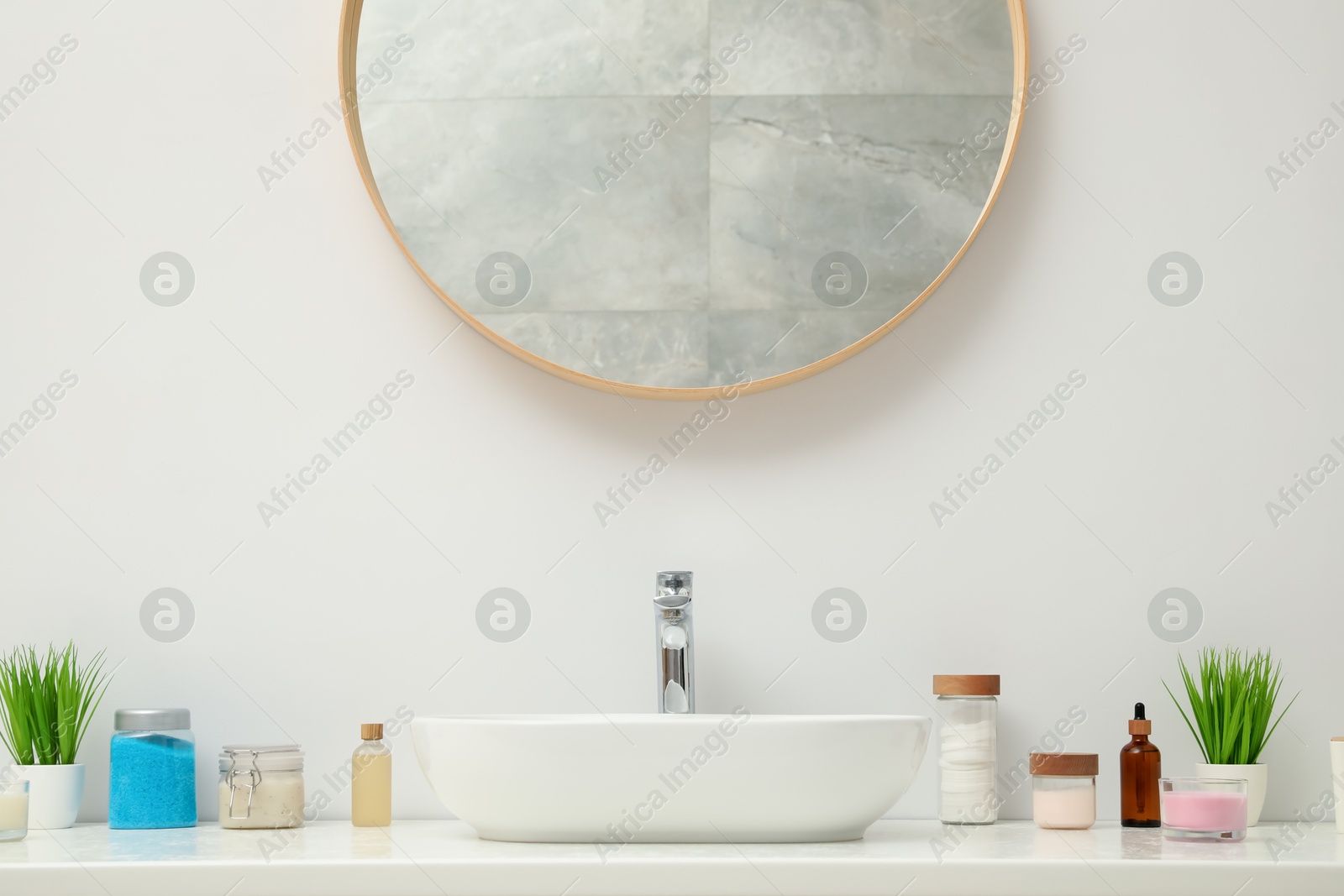 Photo of Countertop with sink, houseplants and mirror in bathroom