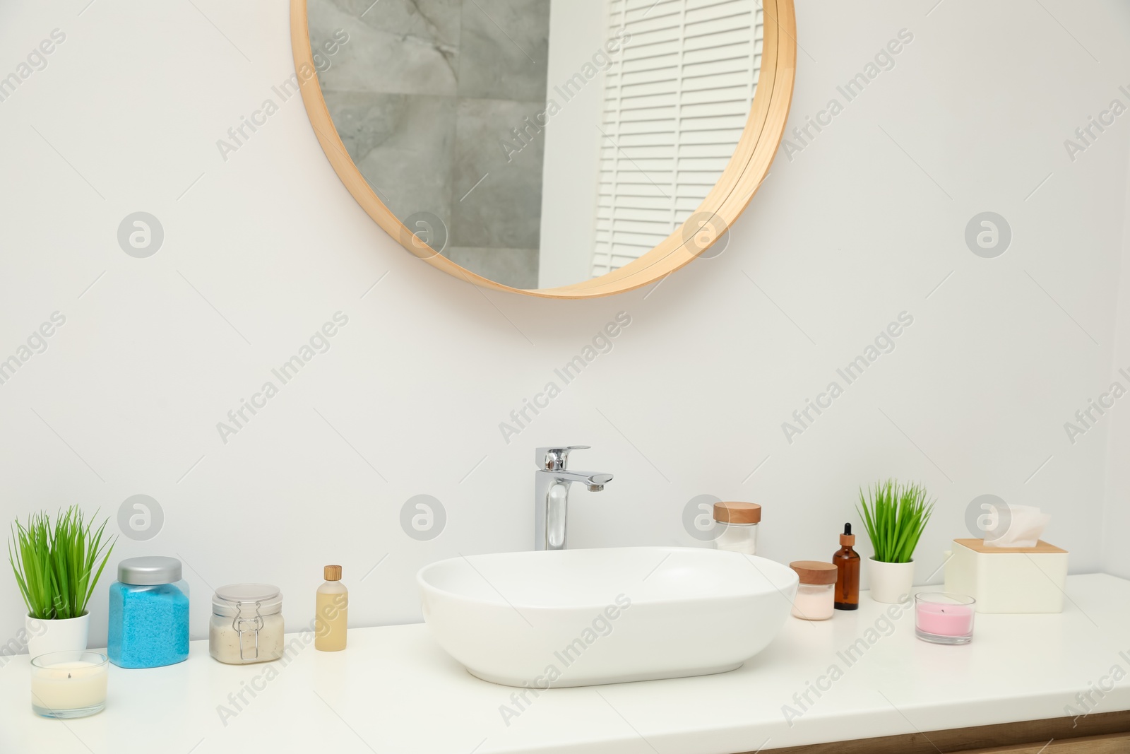 Photo of Countertop with sink, houseplants and mirror in bathroom