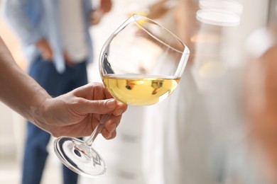 Woman with glass of wine indoors, selective focus