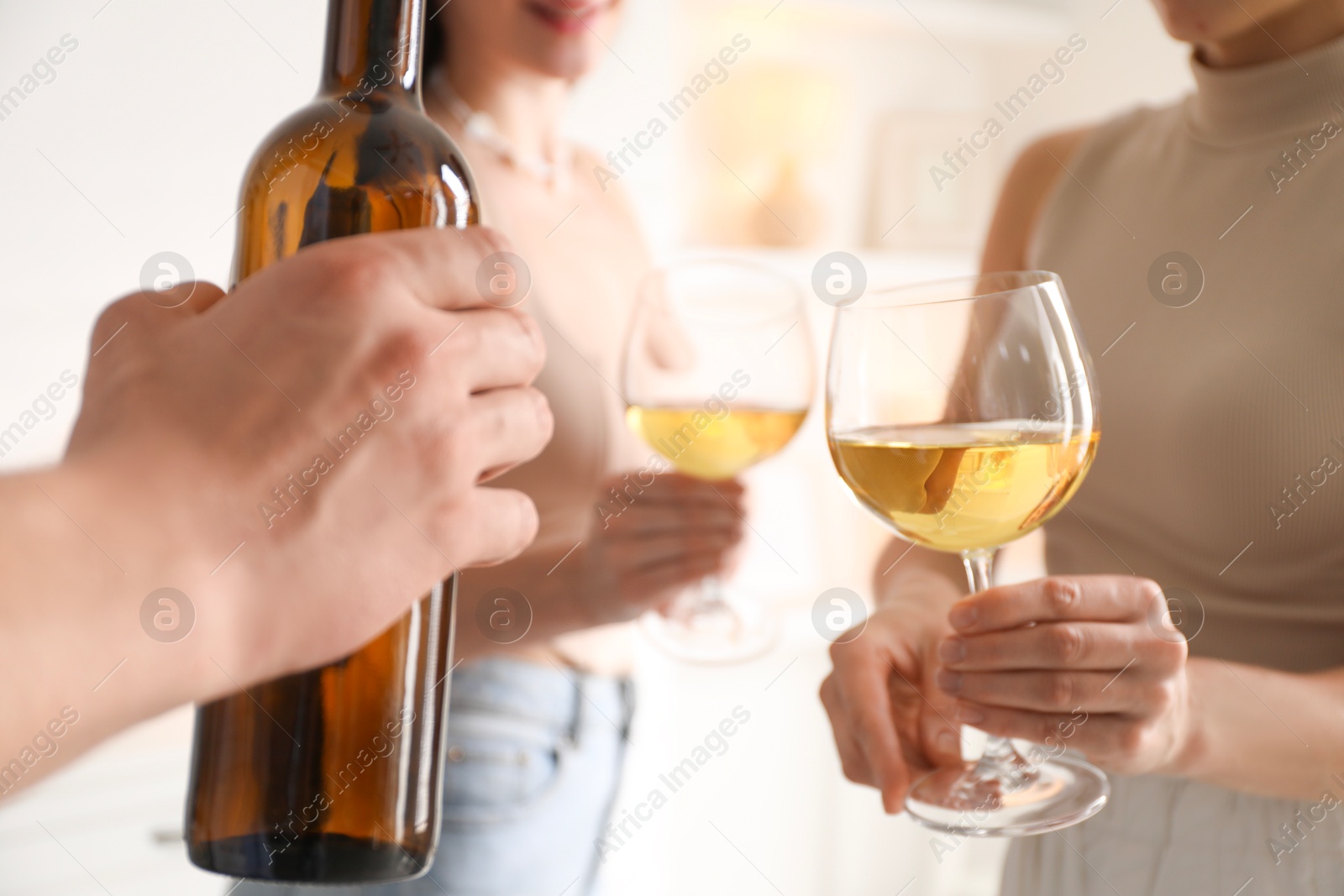 Photo of Friends with glasses of wine indoors, selective focus