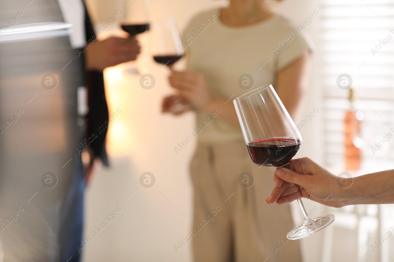 Photo of Woman with glass of red wine indoors, selective focus