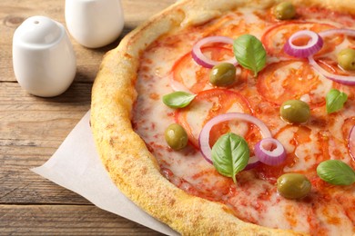 Photo of Delicious vegetarian pizza on wooden table, closeup