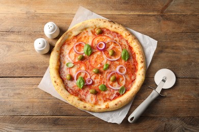 Photo of Delicious vegetarian pizza and cutter on wooden table, top view