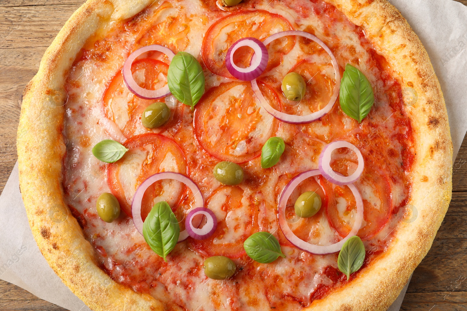 Photo of Delicious vegetarian pizza on wooden table, top view