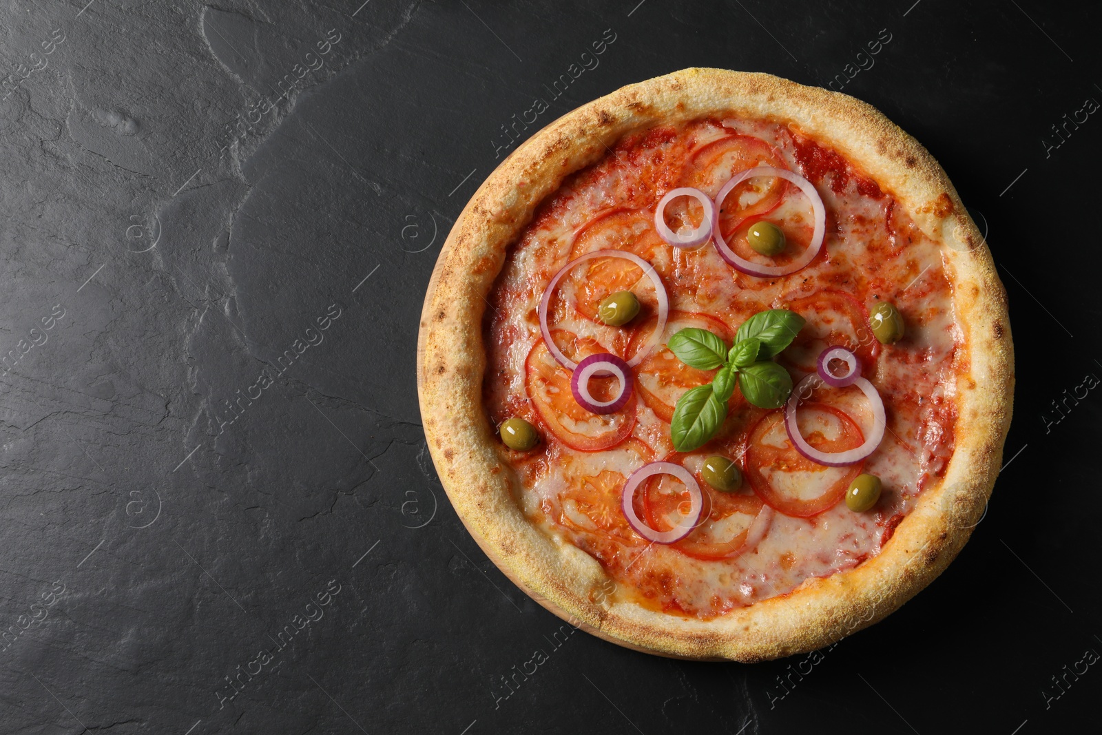 Photo of Delicious vegetarian pizza on black table, top view. Space for text