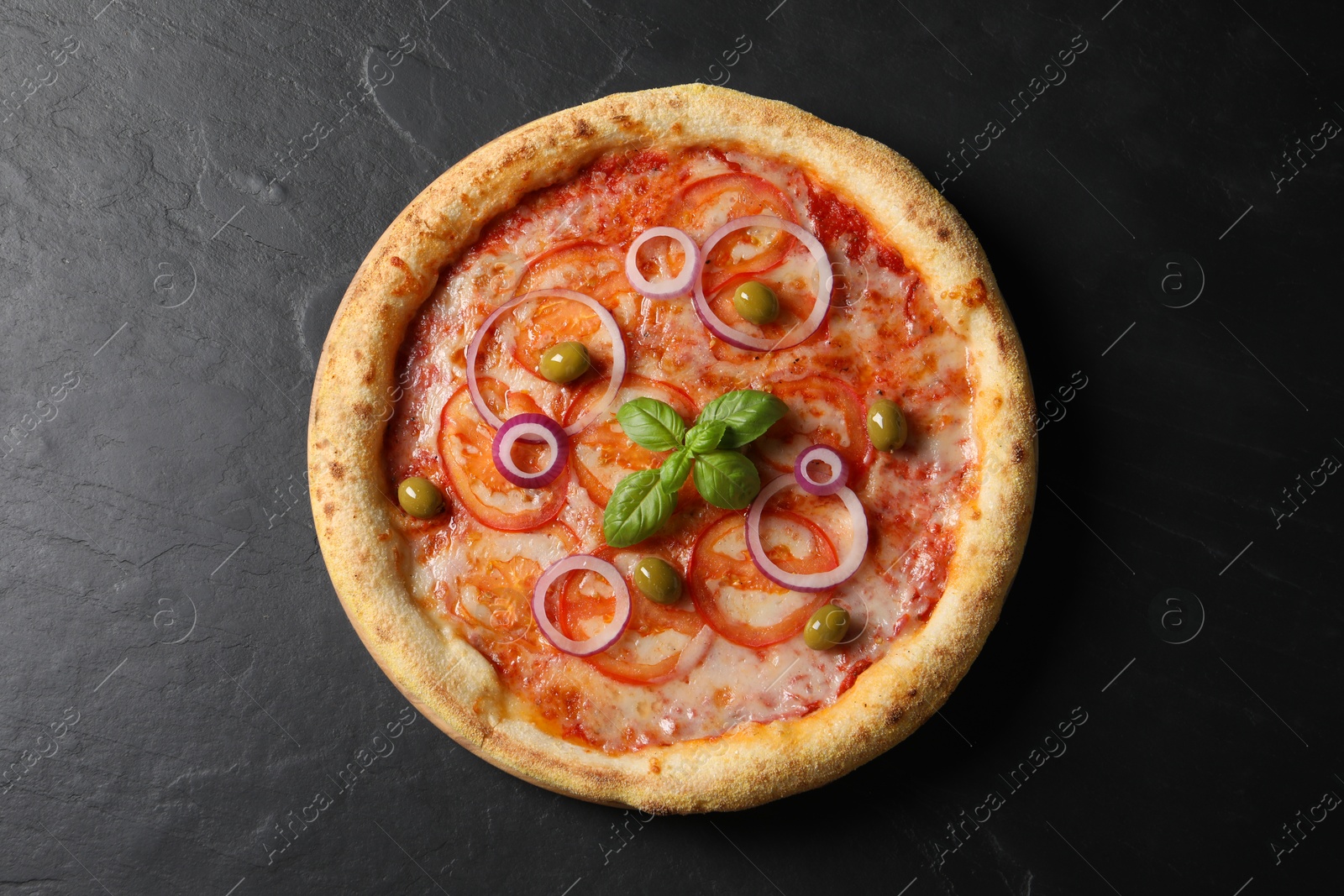 Photo of Delicious vegetarian pizza on black table, top view