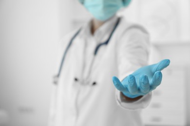 Doctor holding something in clinic, closeup view. Space for text