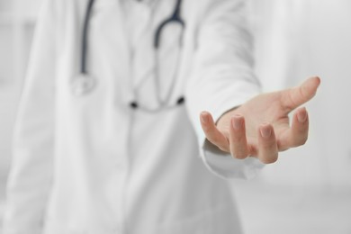 Doctor holding something in clinic, closeup view. Space for text