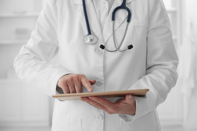 Doctor with tablet in clinic, closeup view