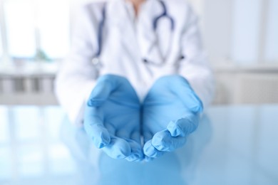 Photo of Doctor holding something at table in clinic, closeup